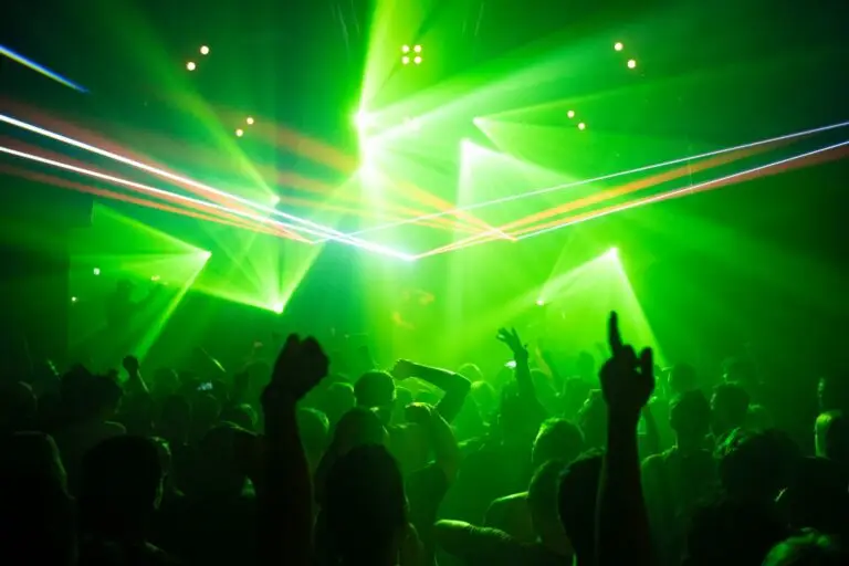 Crowd dancing under lasers during a nightlife event